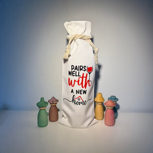 Canvas tas voor wijnfles met de tekst pairs well with a new home - housewarming cadeau - Studio Odelot